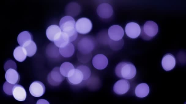 Defokussierte violette Bokeh-Kugeln, die in der Nacht leuchten. abstrakte verschwommene Weihnachtsbeleuchtung Hintergrund — Stockvideo