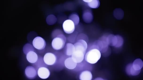 Esferas de bokeh roxo desfocado brilham durante a noite. abstrato embaçado natal luzes fundo — Vídeo de Stock