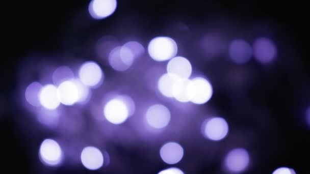 Esferas de bokeh roxo desfocado brilham na noite. abstrato embaçado natal luzes fundo — Vídeo de Stock