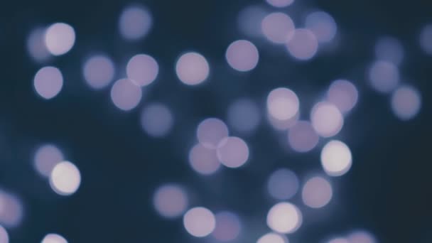 Blaue, verschwommene Weihnachtslichter funkeln im Dunkeln. abstrakte festliche Bokeh Hintergrund — Stockvideo