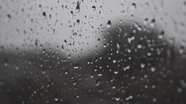 Fuerte lluvia creando gotas de agua en el vidrio de la ventana en el clima de otoño aguacero — Vídeo de stock