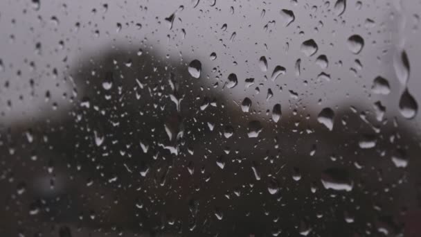 Gotas de agua fluyen hacia abajo en el vidrio de la ventana después de una fuerte lluvia en primer plano detallado — Vídeo de stock