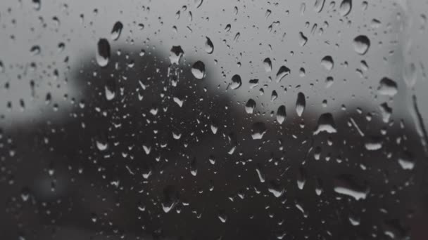 Gotas de água fluem para baixo no vidro da janela após forte chuva em detalhes de perto — Vídeo de Stock