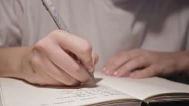 Genç iş kadını, günlük beyaz sayfalarda siyah kalemle el yazısı.
