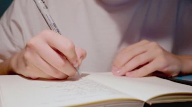 Günlük günlük not defterindeki genç kadın el yazısı yavaş çekimde yakın çekim.