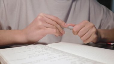 Ağır çekimde kadın elleri kalem kapağını açıyor ve günlük günlüğe yazmaya hazırlanıyor.