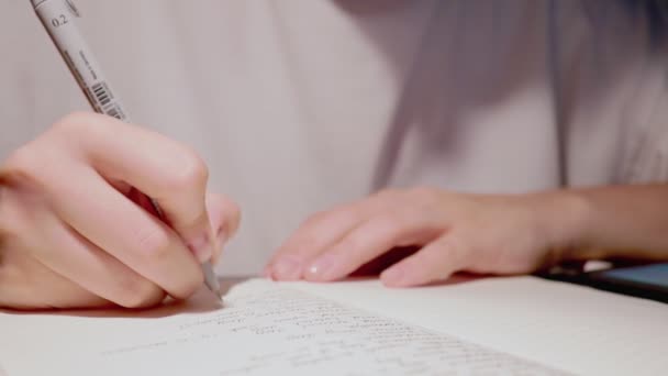Close-up slow motion op vrouwelijke handschrift brief op wit papier pagina zwarte pen — Stockvideo