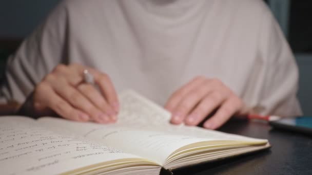 Jonge student draaien wit papier pagina 's zoeken in notebook doen huiswerk — Stockvideo