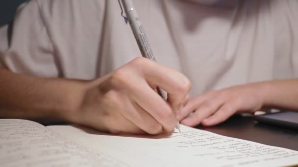 "onherkenbare student doet huiswerk in notebook — Stockvideo
