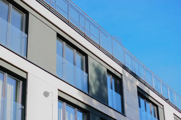 mavi gökyüzü arka planında panoramik pencereleri olan şirket binasının ön cephesinden gri beton duvar