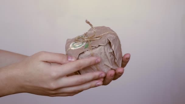 Mãos de mulher segurar criativo caseiro natal presente em reutilizável eco amigável zero resíduos biodegradáveis papel artesanal embrulho presente, materiais reciclados orgânicos — Vídeo de Stock