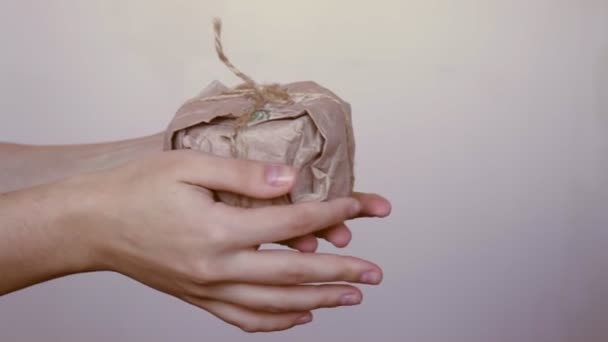 Γυναικεία χέρια κατέχουν δημιουργική σπιτικό χριστουγεννιάτικο δώρο σε επαναχρησιμοποιήσιμα φιλικά προς το περιβάλλον μηδέν απόβλητα βιοδιασπώμενα βιοδιασπώμενα χαρτί περιτύλιγμα δώρου, οργανικά ανακυκλωμένα υλικά — Αρχείο Βίντεο
