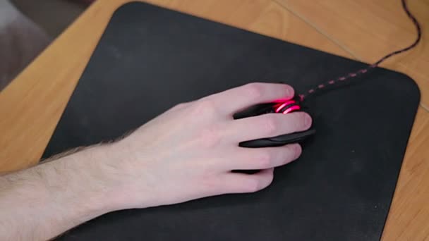 Giovane giocatore maschio mano sul mouse del computer in movimento al rallentatore sul tappetino nero del mouse — Video Stock