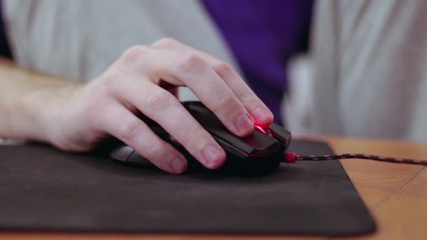 Detailed close up on young male gamer hand on computer mouse on black mouse pad — Stock Video