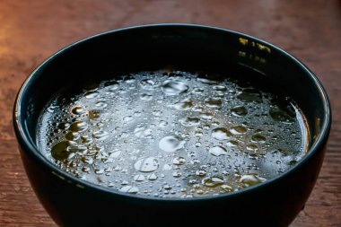 Mavi çorba kasesinde su dokusunda yağ