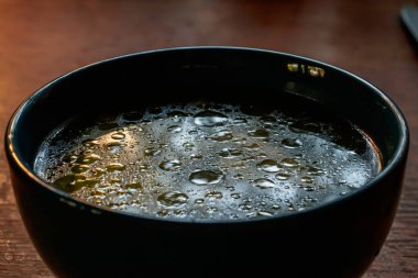 Mavi çorba kasesinde su dokusunda yağ