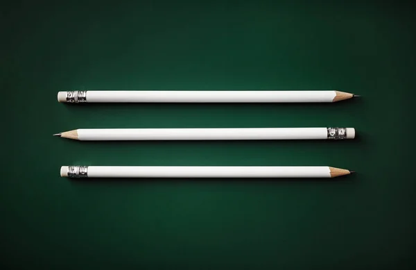 Három Fehér Ceruza Zöld Háttérrel Lapos Fektetés — Stock Fotó
