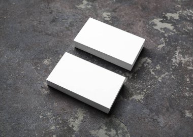 Beton arka planda boş beyaz kartvizitler. Marka kimliği için model.