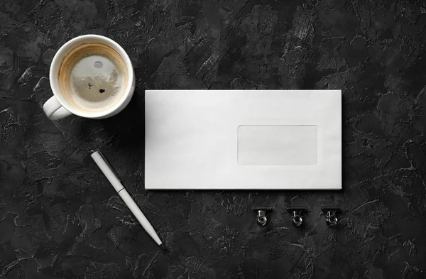 黒の石の背景に空白の封筒 コーヒーカップ ペンとクリップ 空の文房具セット — ストック写真