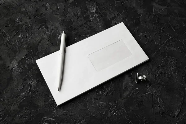黒い石の背景に白い紙の封筒 ペンとクリップの写真 空白の文房具テンプレート — ストック写真