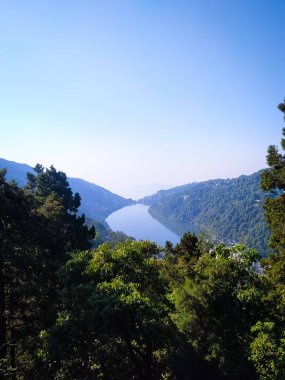 A beautiful Nainital Hill Station located in Uttarakhand of India. Aerial view of mango shaped Naini Lake in Uttarakhand, India. Green landscape of Nainital Lake with vibrant nature of Himalaya mountains in India