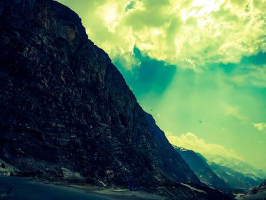 Dağların üzerinde bulutlarla güzel bir günbatımı gökyüzü