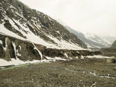 Karla kaplı dağlar ve akan nehirlerle kaplı manzara