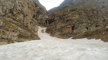 Dağların arasındaki pınar, karlar donuyor..