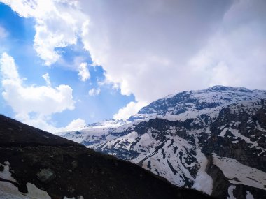 Güzel bir kar dağının üzerinde beyaz bulutlar.