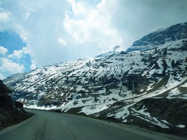Karla kaplı dağlarda gökyüzü bulutlu seçici bir odak noktası.