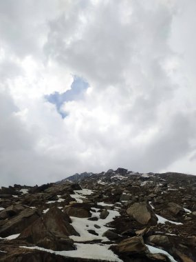 Karla kaplı kayaların üzerinde seçici beyaz bulutlar