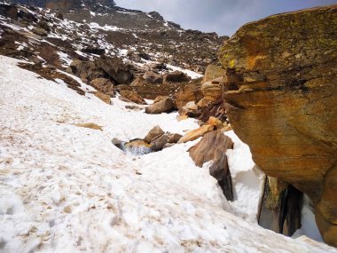 Büyük taş parçalarını kardan bir dağın üzerine odakla.