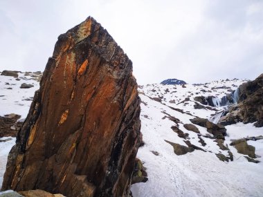 Manali, Himachal Pradesh köyü yakınlarındaki pitoresk Hindistan 'da bulutlu gökyüzü, dağların geniş kayalık çıkıntıları ile kaplı ilk karla kaplı harika manzaralar.
