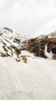 Karlı manzaradan, bulutlu yüksek karlı dağ sırasına kadar harika bir manzara. Bulutlu gökyüzünün altında kar dağları olan atmosferik manzara