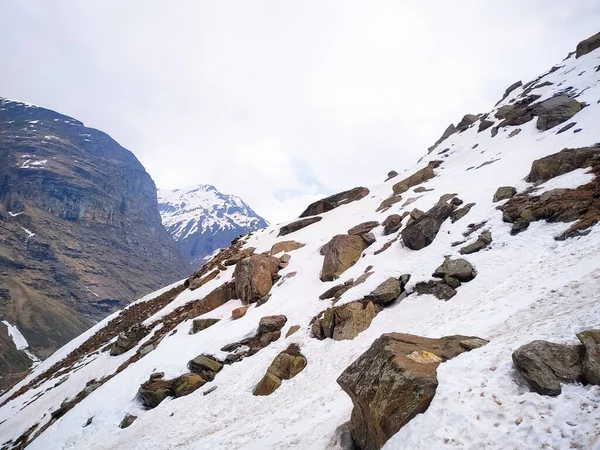 Karla kaplı gökyüzü bulutlu dağlara seçici odak taşları