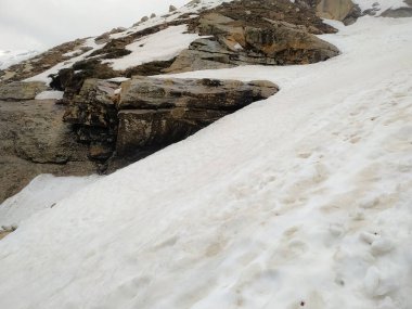 Dağlarda beyaz kar, karlı dağ manzarası, dağlarda taşlar.
