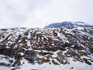 Bulutlu arka planda karlı dağlar