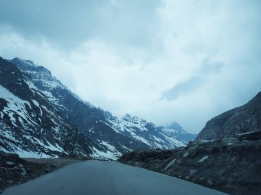 Karlı dağların ortasında asfalt yol