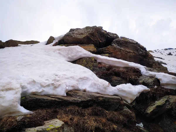 Yaz mevsiminde kayaların tepesinde donmuş kar.