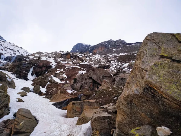 Bazı taşlar gökyüzüne karşı dağda karla kaplı..