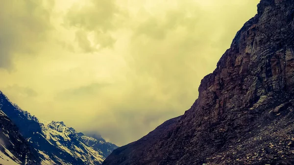 Dağların üstünde dramatik bir gün batımı. Muhteşem günbatımında ya da gün doğumunda engebeli kayalık dağlar.