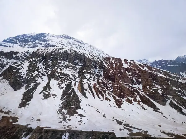 Yazın karla kaplı dağlar gökyüzüne karşı.