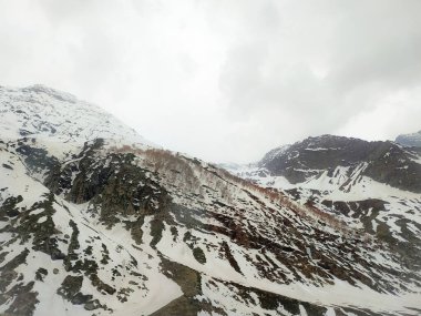Güzel karlı dağların manzarası ve manzarayı ve barajı kaplayan bir bulut.
