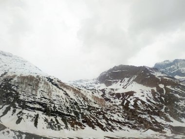 Karla kaplı dağ bulutlu gökyüzüne karşı