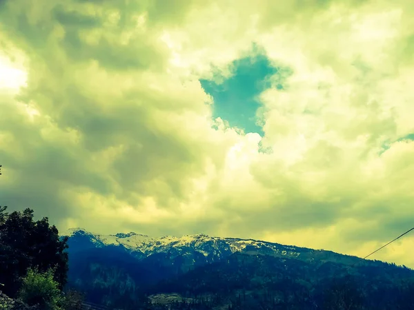 Karların Üzerinde Sarı Bulutlar Ağaçlarla Kaplı Dağlar — Stok fotoğraf
