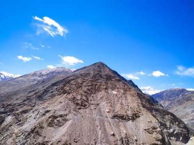 Mavi gökyüzünde bulutlu Spiti Vadisi manzarası