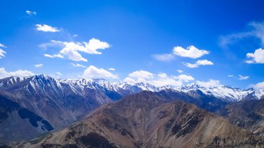 Yüksek Himalaya dağları, bulutlu mavi gökyüzü ve Hindistan 'da yaz mevsiminde güneş ışığı olan inanılmaz bir manzara. Dağ vadisi. Himalayalar 'da seyahat et. Doğa