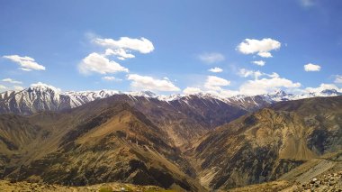 Yüksek Himalaya dağlarıyla Spiti Vadisi 'nin muhteşem manzarası, Hindistan' da sonbaharda bulutlu mavi gökyüzü ve güneş ışığı. Dağ vadisi. Himachal Pradesh 'e git. Doğa