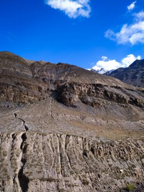 Gökyüzü ve bulutlarla kaplı dağ manzarası