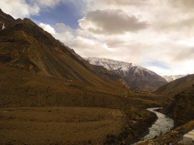 Dağlardan akan bir nehrin üzerinde bulutlar